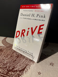 Book titled 'Drive' by Daniel H. Pink on a textured surface