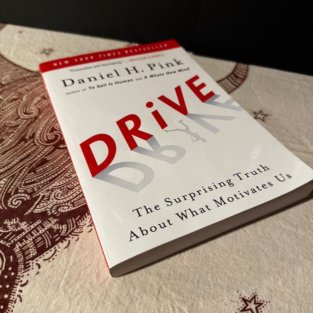 Book titled 'Drive' by Daniel H. Pink on a textured surface