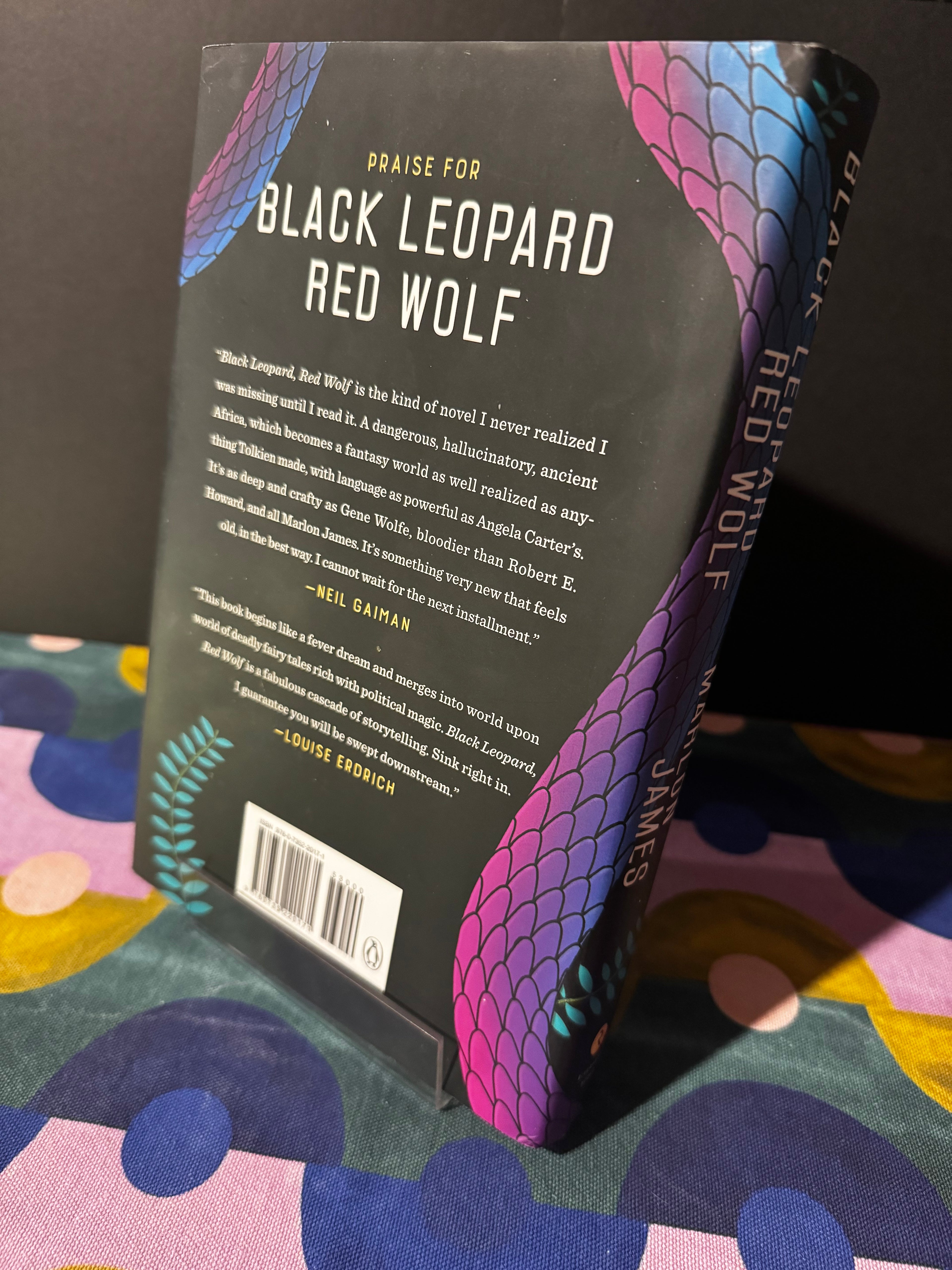 Book titled 'Black Leopard, Red Wolf' by Marlon James on a colorful background