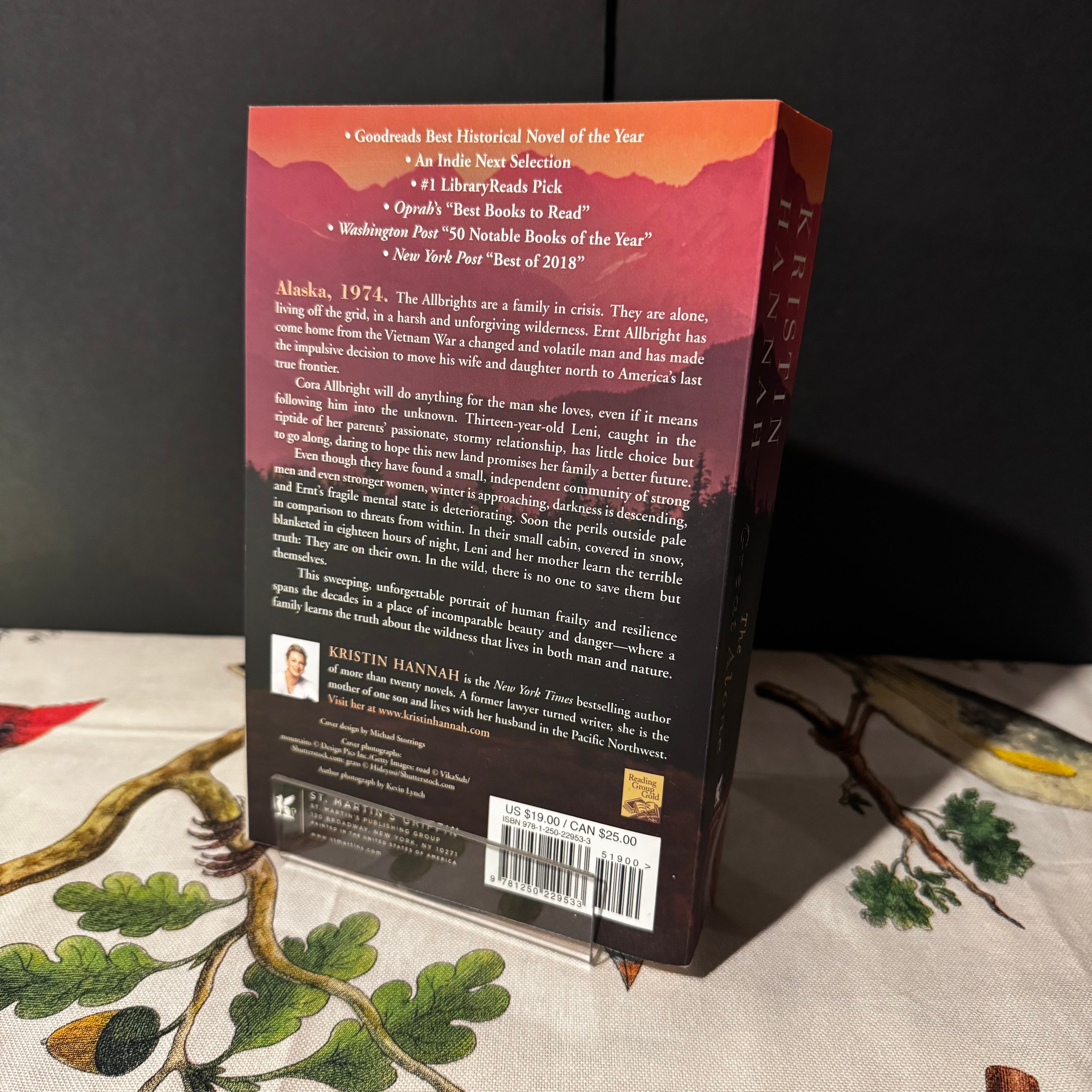 Back cover of a book with text and a barcode on a textured surface with natural elements.