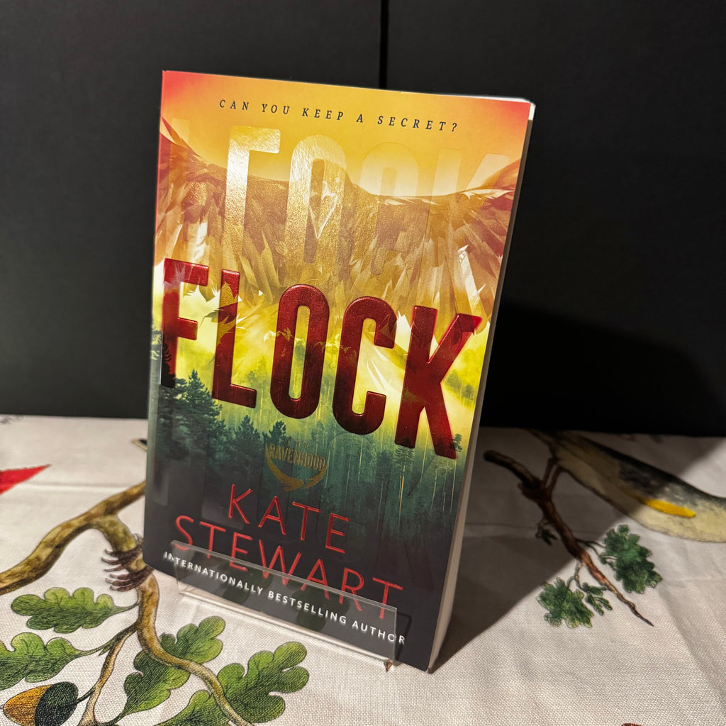 Book titled 'Flock' by Kate Stewart on a table with a dark background
