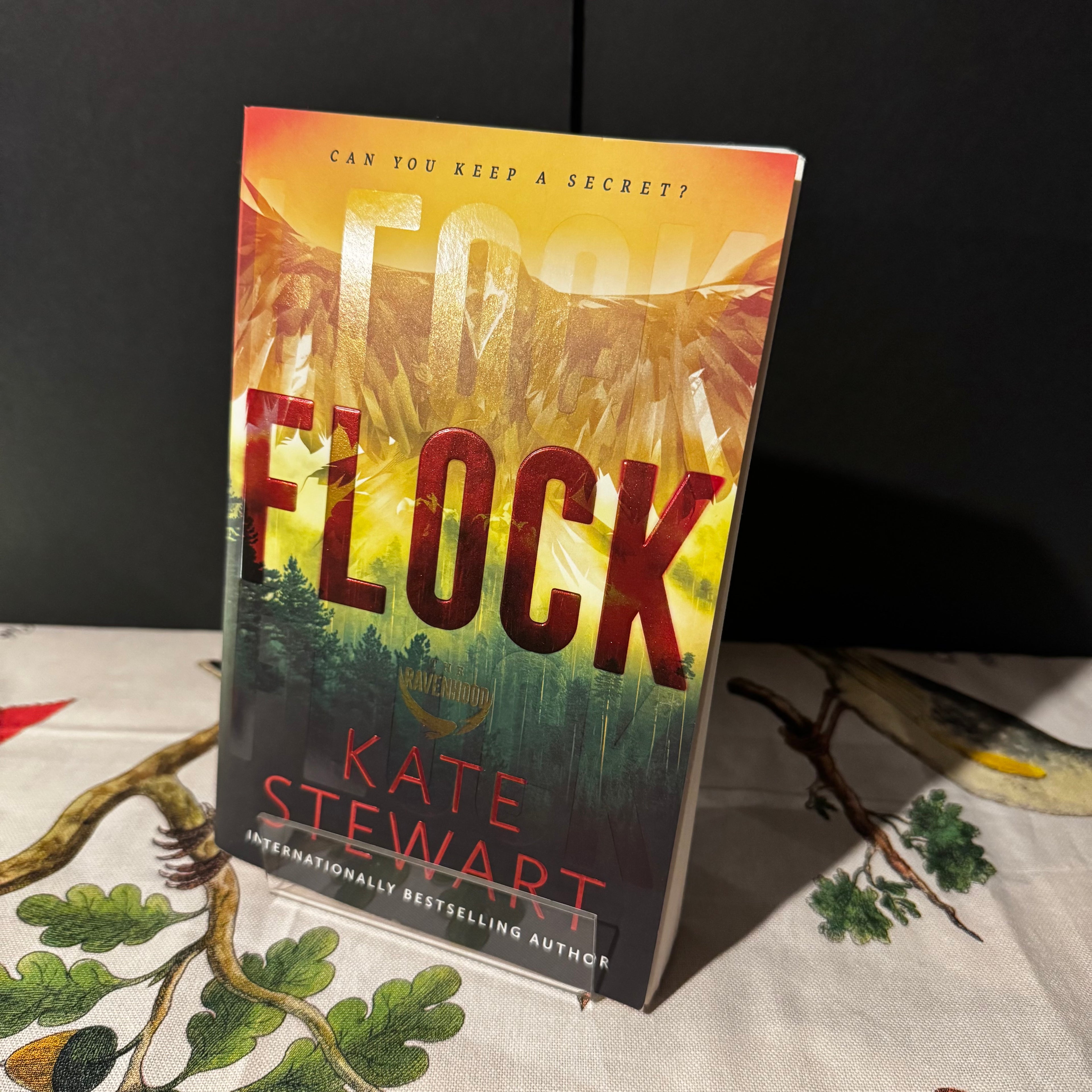 Book titled 'Flock' by Kate Stewart on a table with a dark background