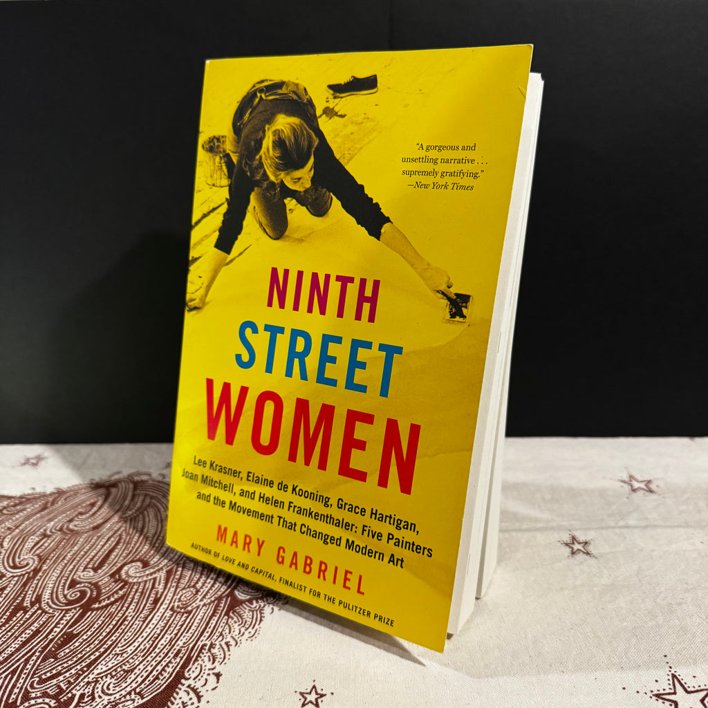 Book titled 'Ninth Street Women' by Mary Gabriel on a textured surface with a dark background