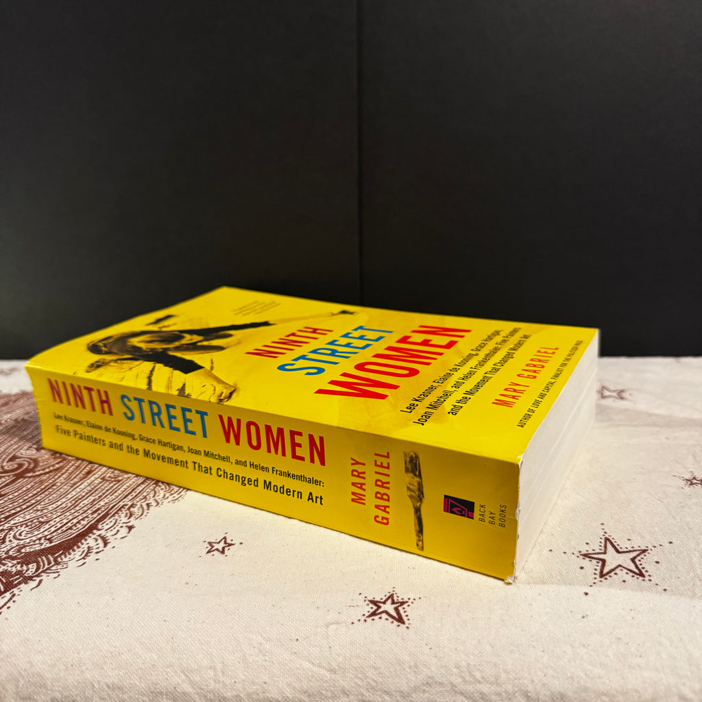 Book titled 'Ninth Street Women' by Mary Gabriel on a textured surface with a dark background