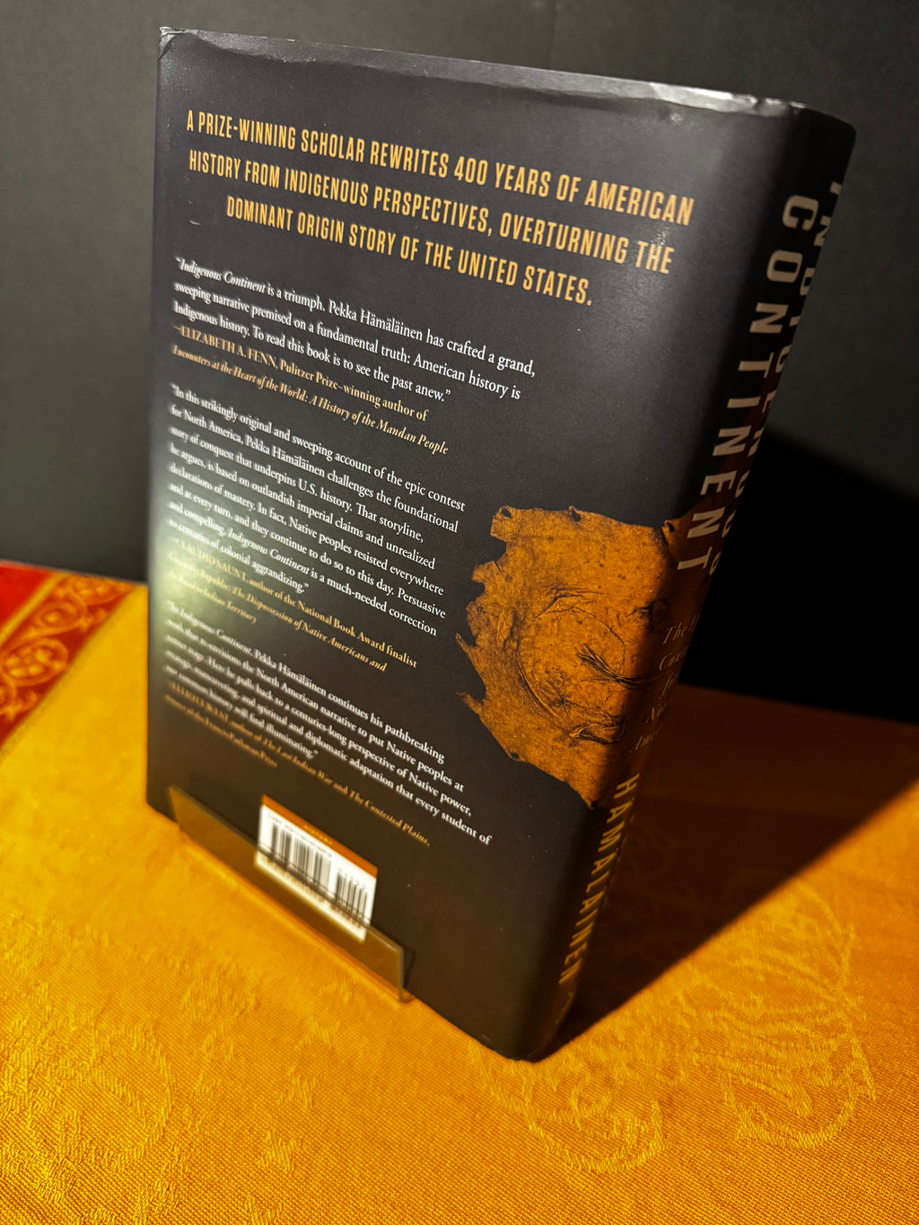 Book cover with text and a portrait on a yellow background
