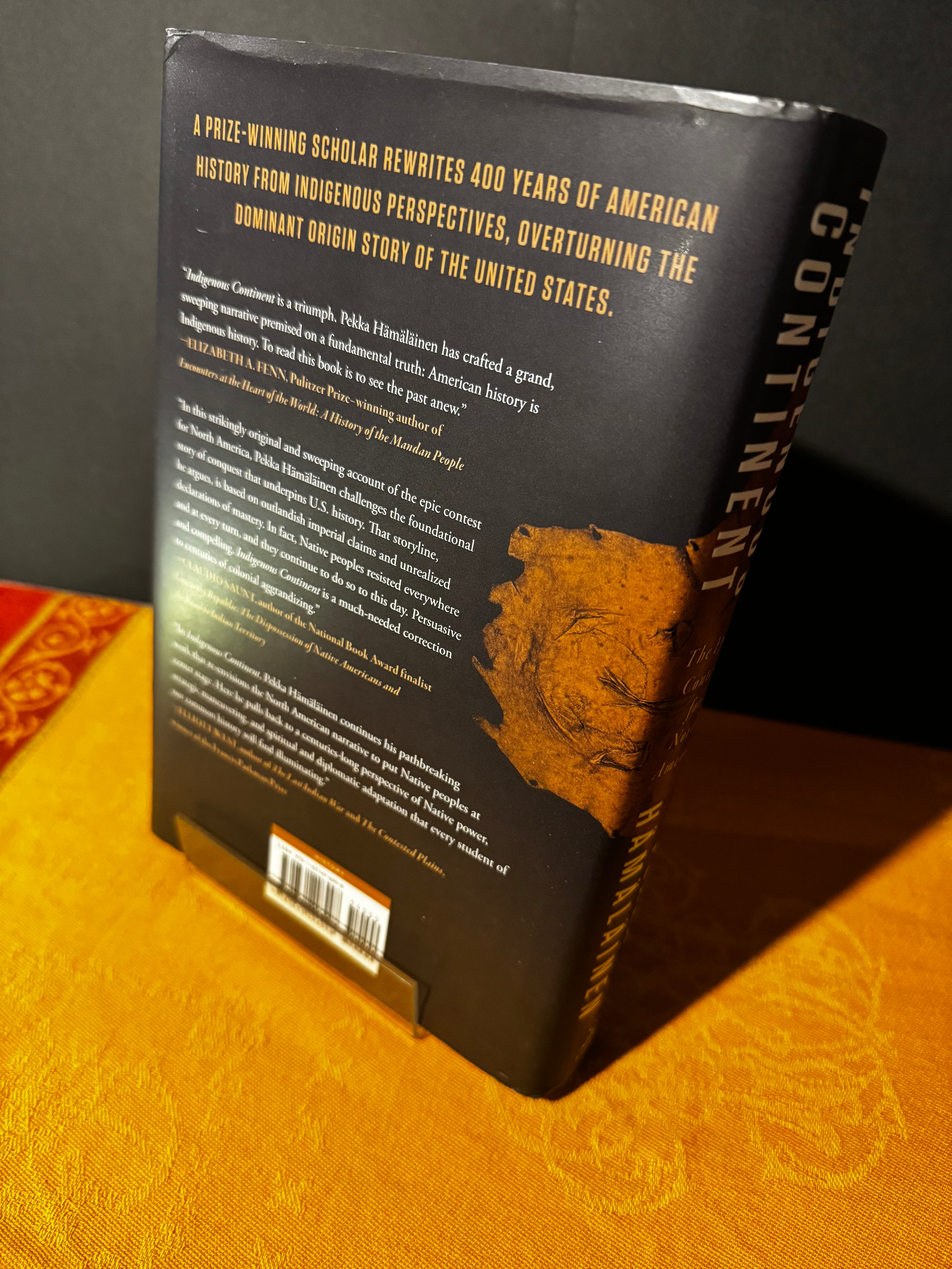 Book cover with text and a portrait on a yellow background